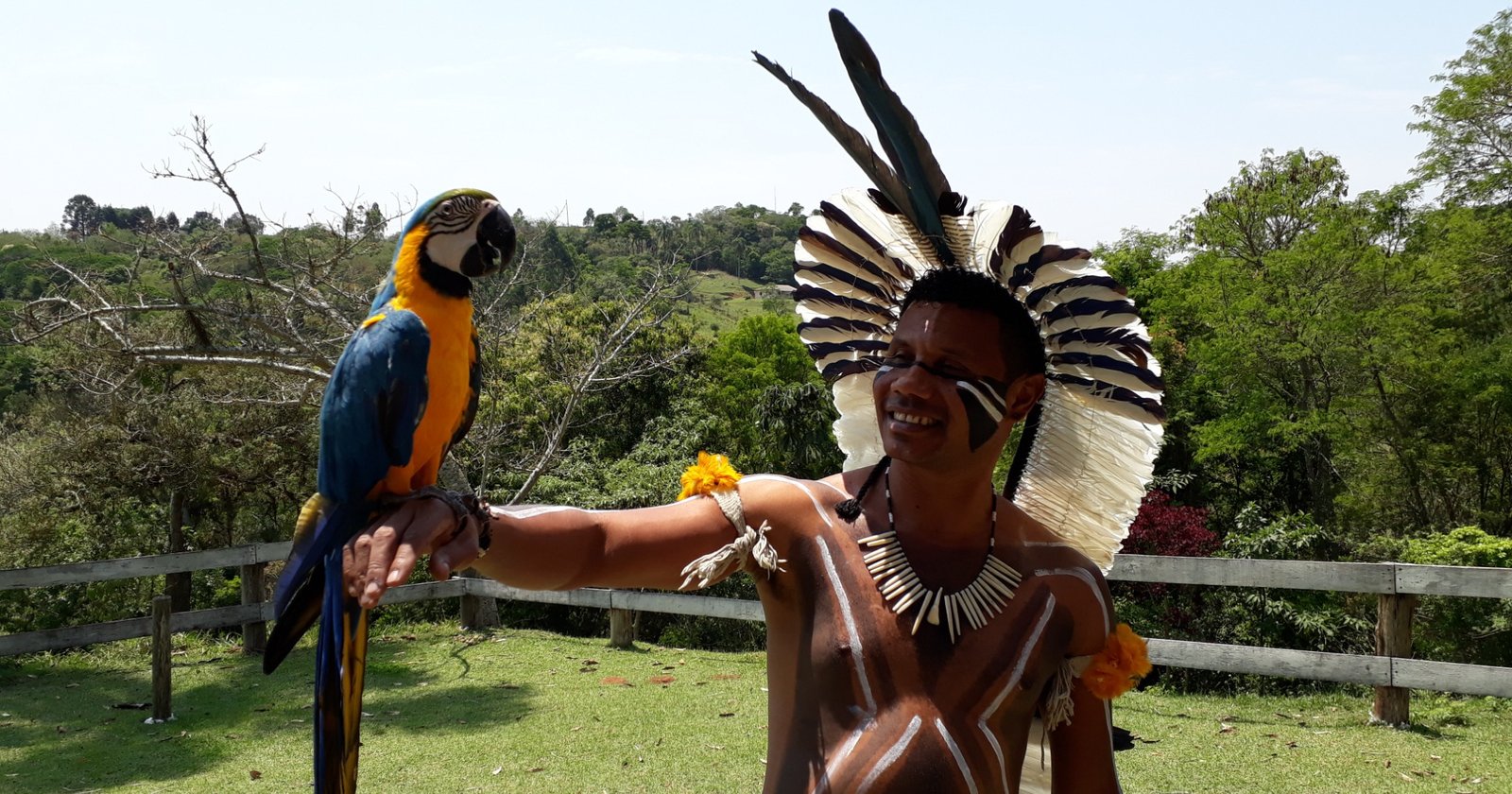 Cacique Kayrrá Kariri-Xocó com uma arara azul e amarela ao ar livre